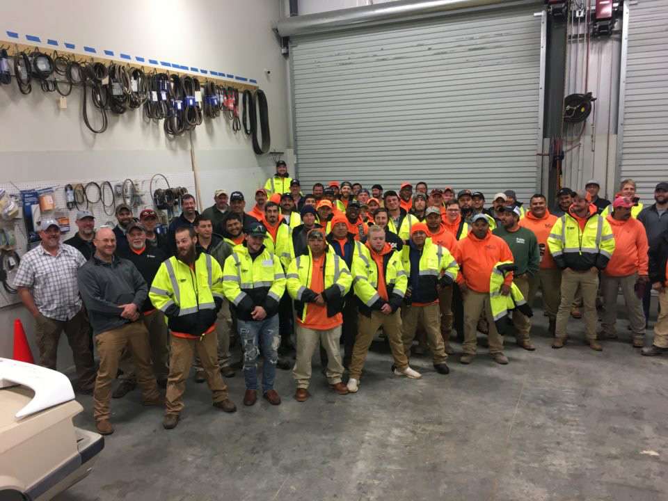 Group of workers in safety gear posing in a warehouse in Metro Atlanta