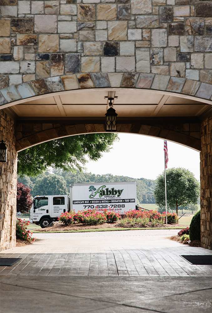 Abby Group landscaping truck passing through an archway in Metro Atlanta