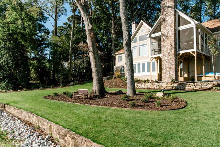 Backyard with trees, lawn, and a stone retaining wall in Metro Atlanta